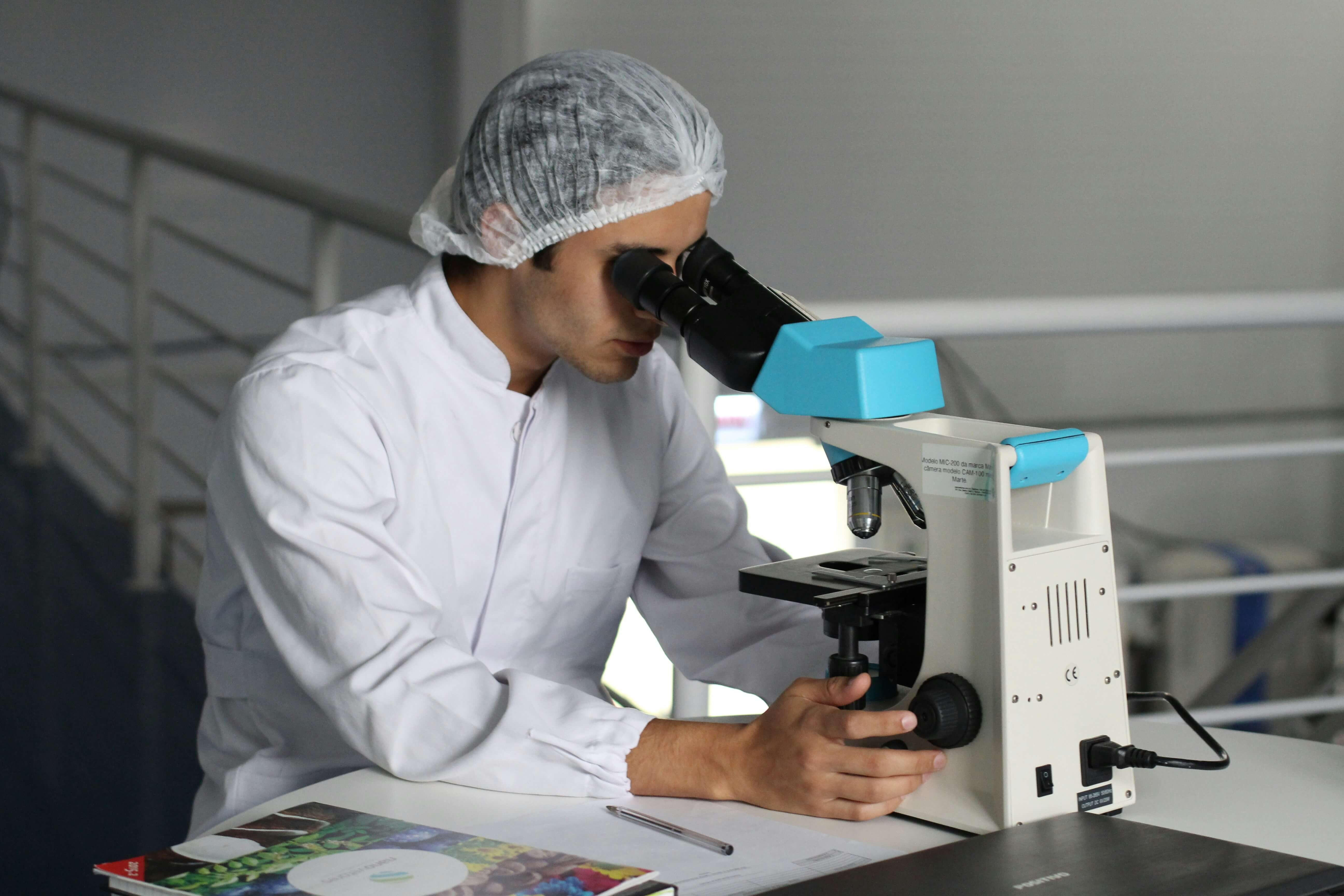 Doctor examining samples through a professional microscope